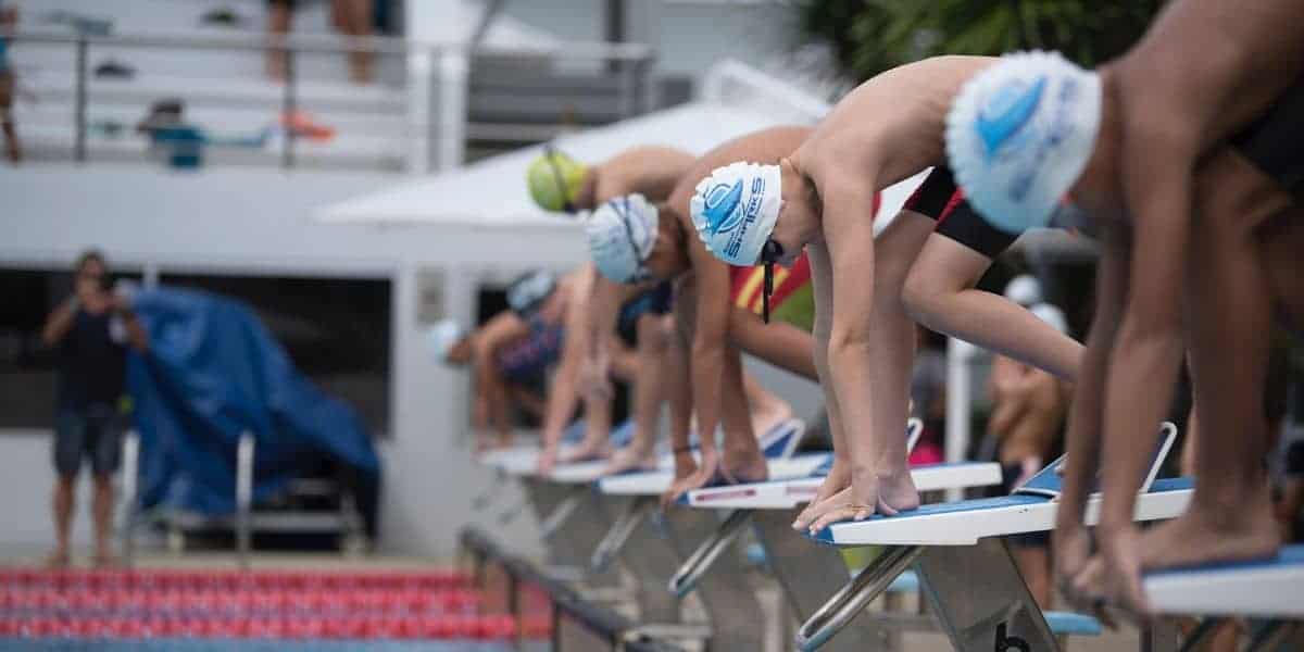 Age group swimmers on starting blocks