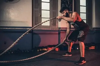 swimmer training with battle ropes